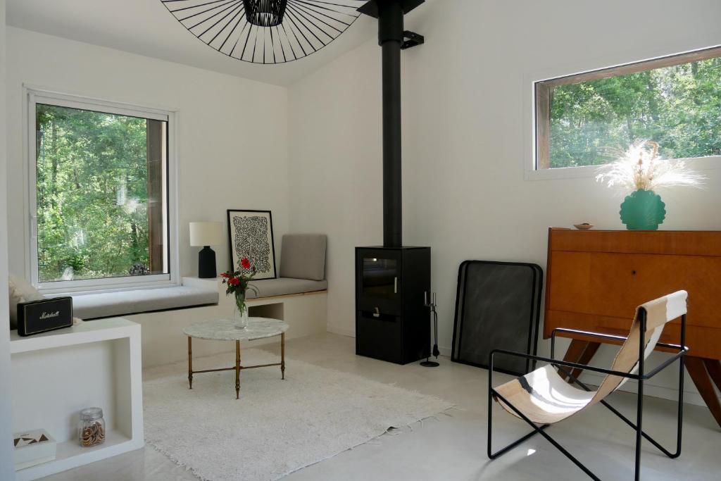 ein weißes Wohnzimmer mit einem Tisch und Stühlen in der Unterkunft Maison de vacances, proche Océan, idéal famille in Saint-Vivien-de-Médoc