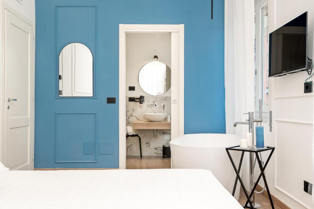 a bedroom with a blue door and a sink at Nelli Rooms Via Veneto in La Spezia