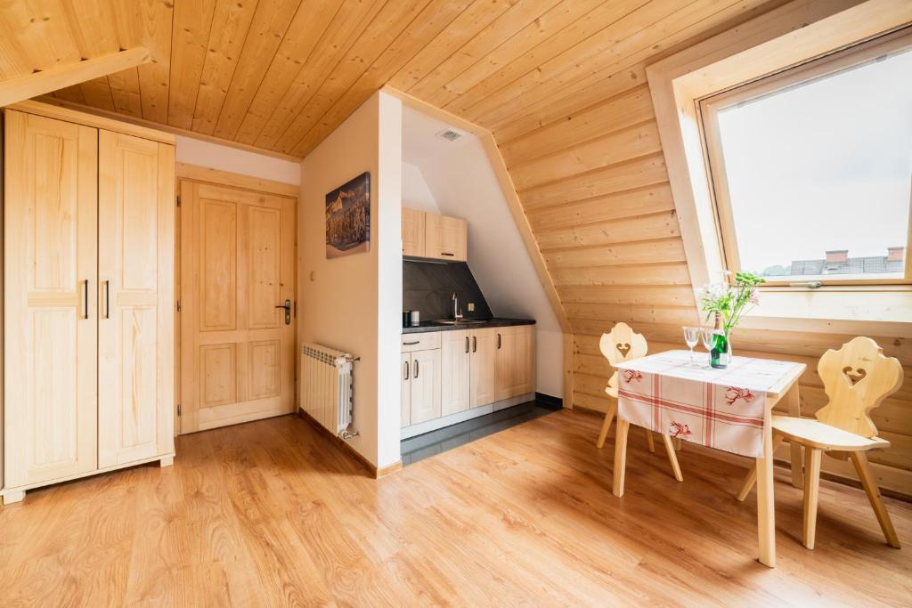 a room with a kitchen with a table and a window at Pokoje Gościnne Pod Łosiówkami in Poronin