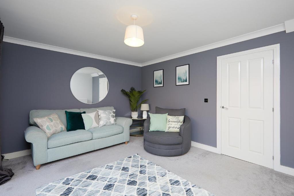 a living room with two couches and a mirror at Royal Derby Hospital 3 bed Town House in Derby