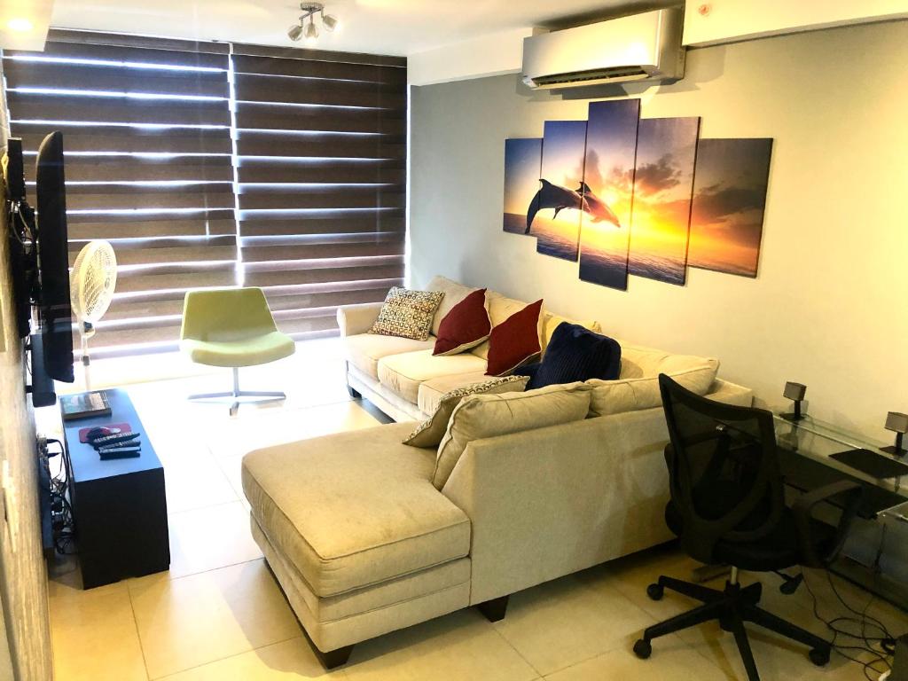 sala de estar con sofá y escritorio en Navona Towers Amplio Apart, Dos Noches minimo, para 4 personas lo mejor de Panamá en Panamá