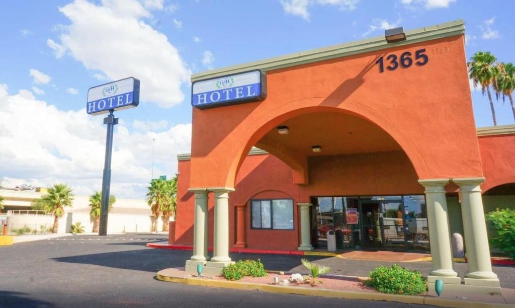 un edificio rosso con un cartello per un hotel di GLH Hotel a Tucson