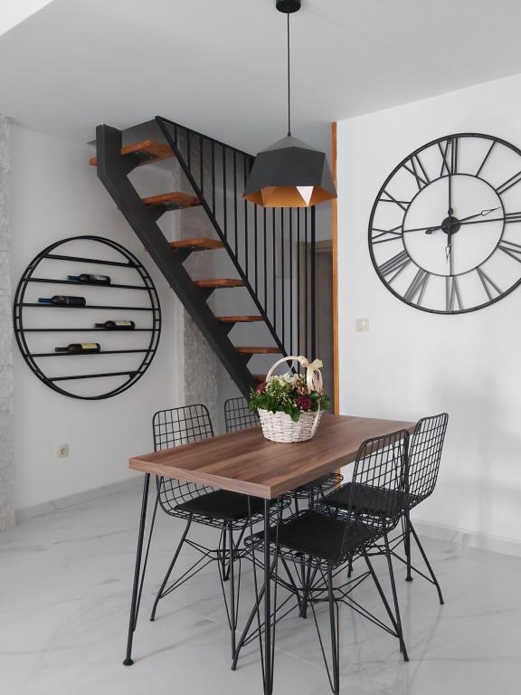 una mesa de comedor con sillas y una escalera en Apartments "4You", en Tivat