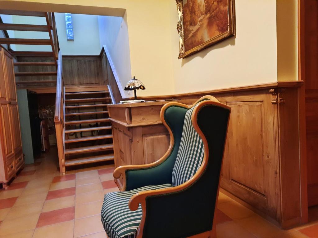 a chair in a room with a stair case at Ágnes Vendégház in Tokaj