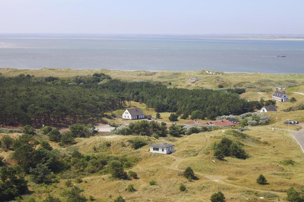 eine Luftansicht eines Hauses auf einem Hügel in der Nähe des Wassers in der Unterkunft Sier aan Zee in Hollum