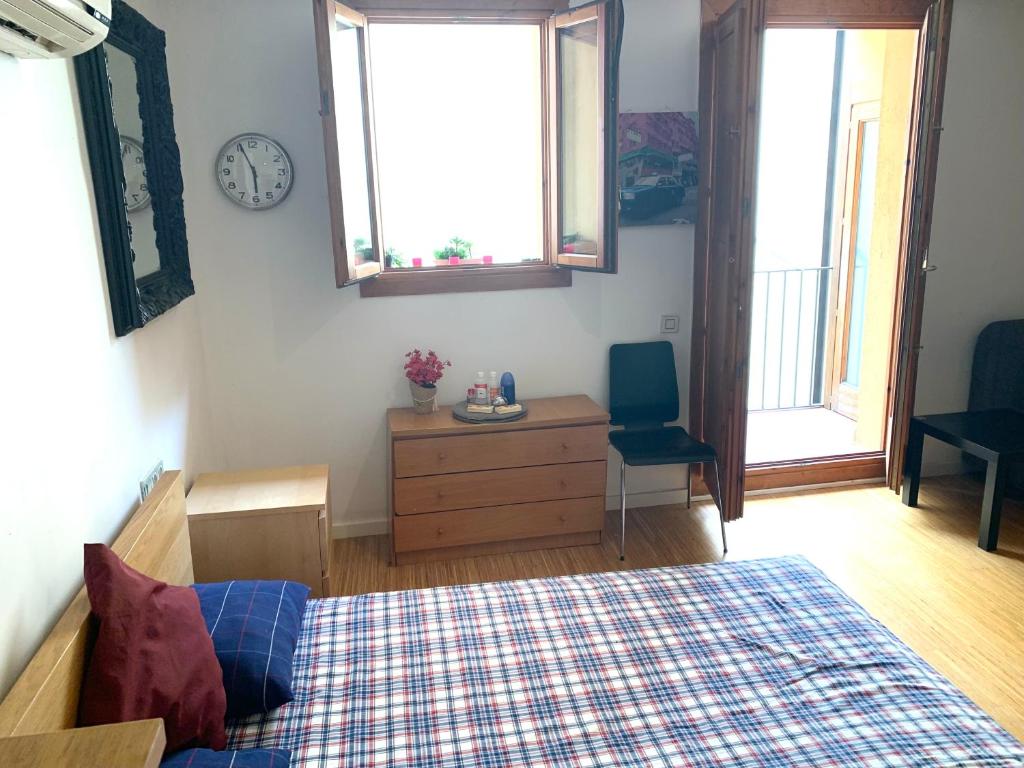 een slaapkamer met een bed en een klok aan de muur bij Apartment next to Ramblas in Barcelona