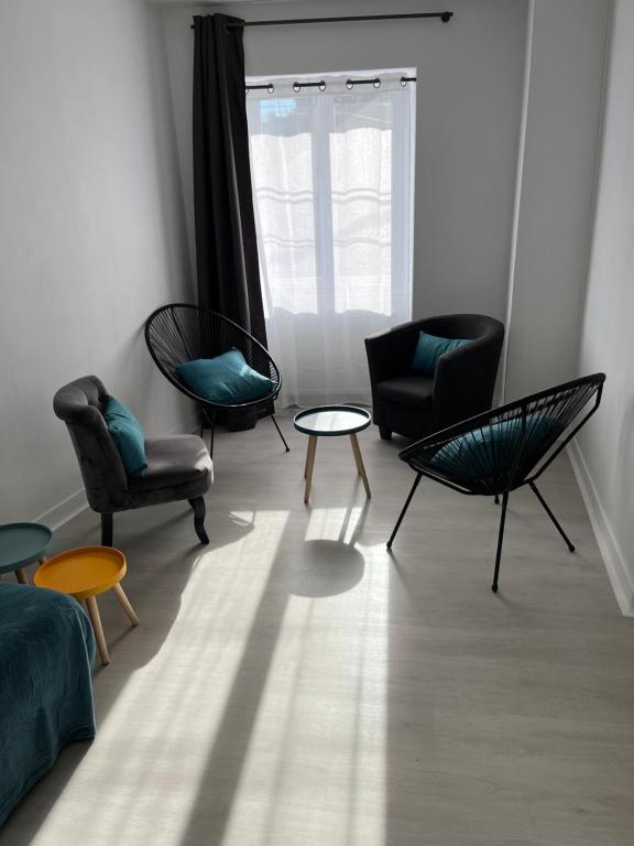 - un salon avec des chaises, une table et une fenêtre dans l'établissement Charmante maison de ville avec parking à côté., à Morlaix