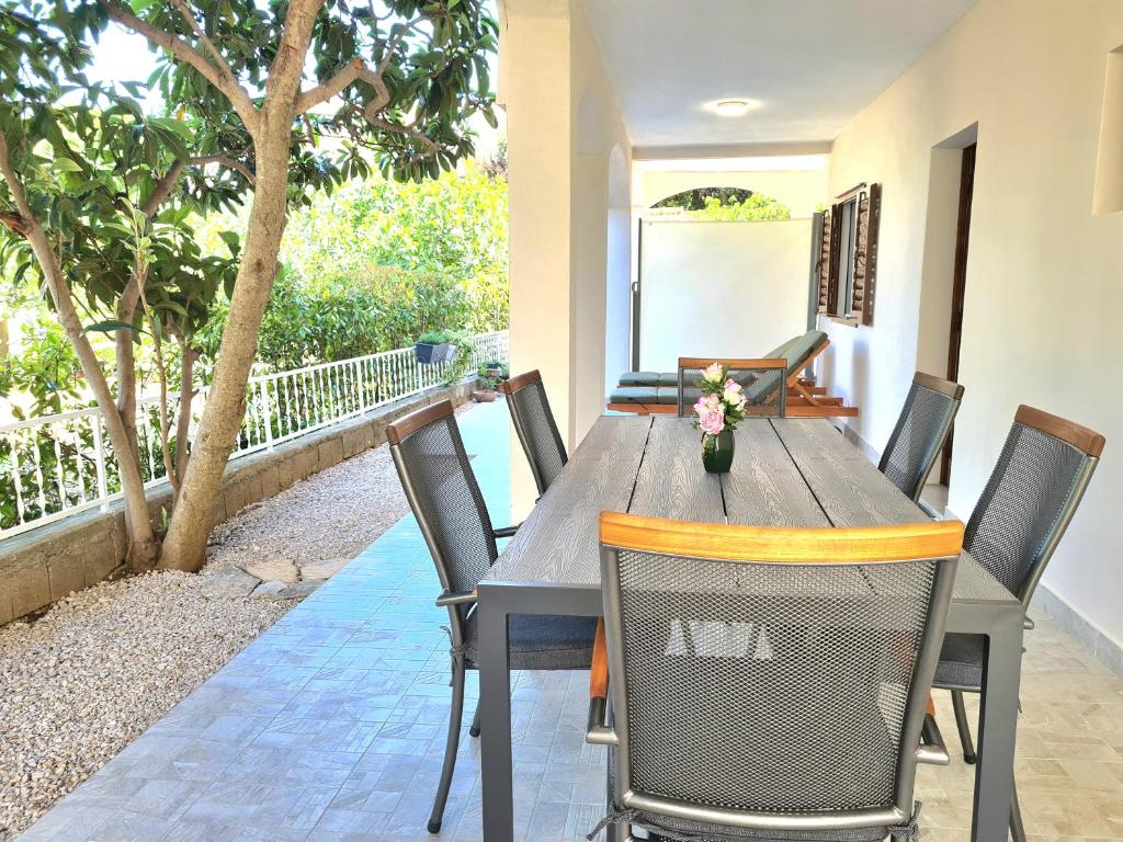 a dining table and chairs on the patio of a house at APARTMENT IVANA in Brodarica
