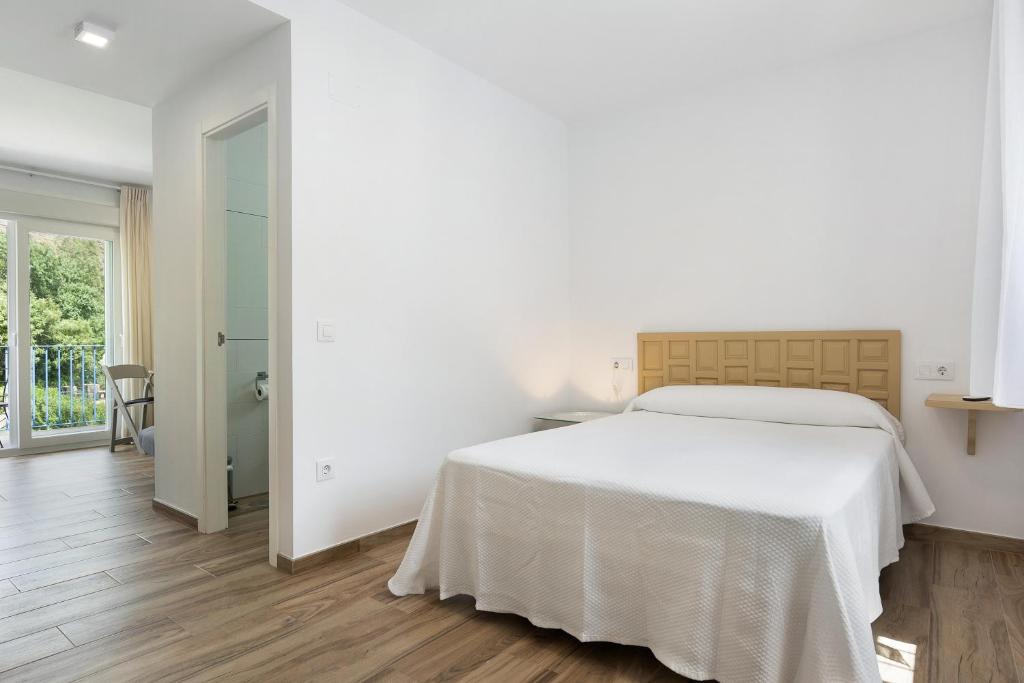 sypialnia z dużym białym łóżkiem i łazienką w obiekcie Casa de 10 - 5a w mieście Vejer de la Frontera