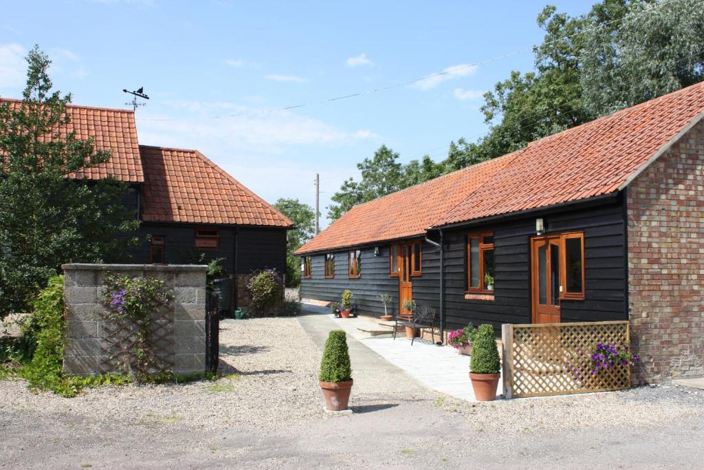 un par de edificios con plantas delante de ellos en Puttocks Farm, en Great Dunmow