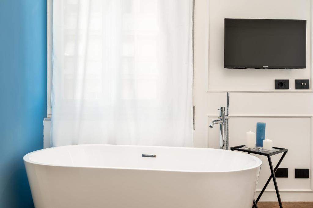 Televízia a/alebo spoločenská miestnosť v ubytovaní Nelli Rooms Via Veneto