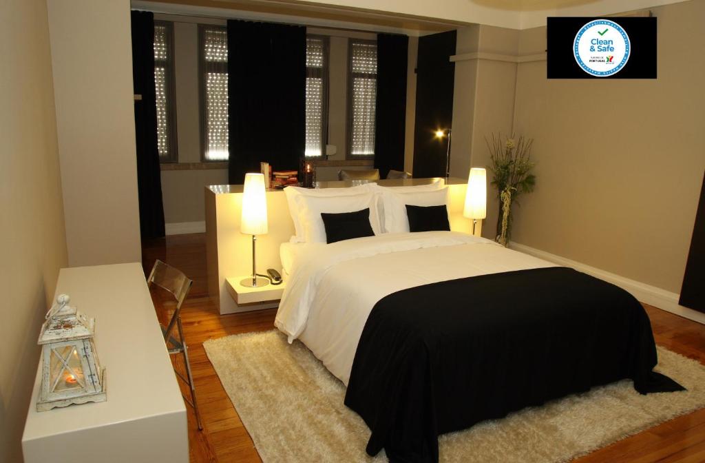 a bedroom with a black and white bed and two lamps at Castilho House in Lisbon