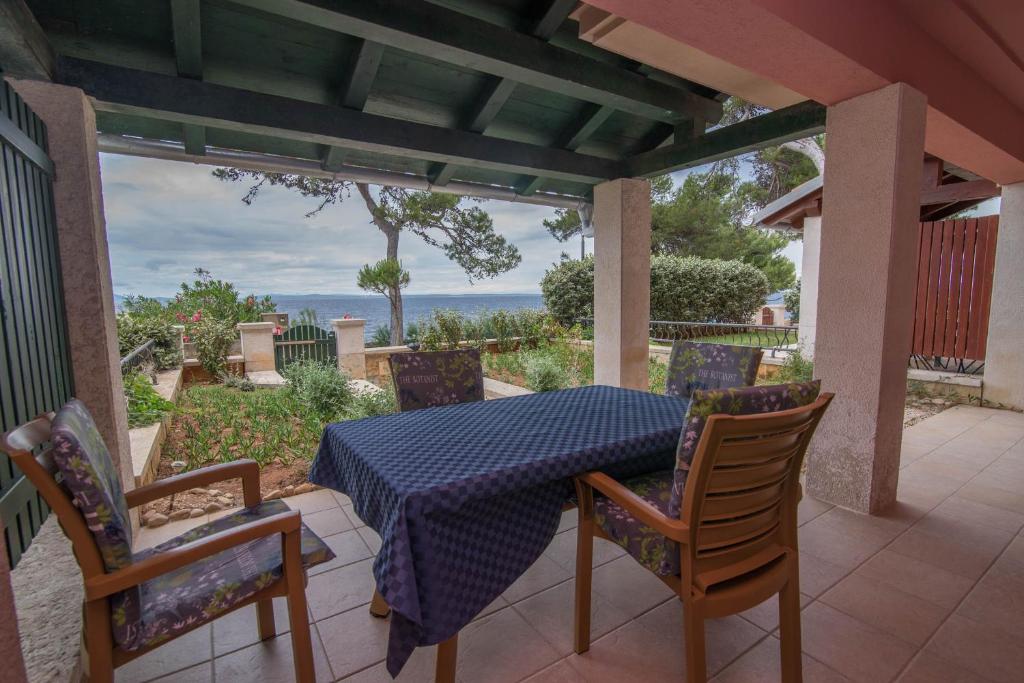 una mesa y sillas en un patio con vistas al océano en Apartman Punta A2+2 en Veli Lošinj