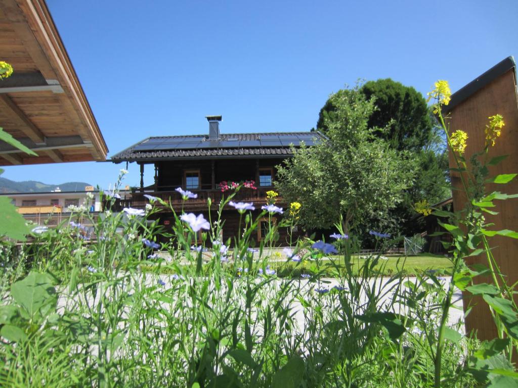 a garden with flowers in front of a house at Chalet Fasserhäusl in Finsing
