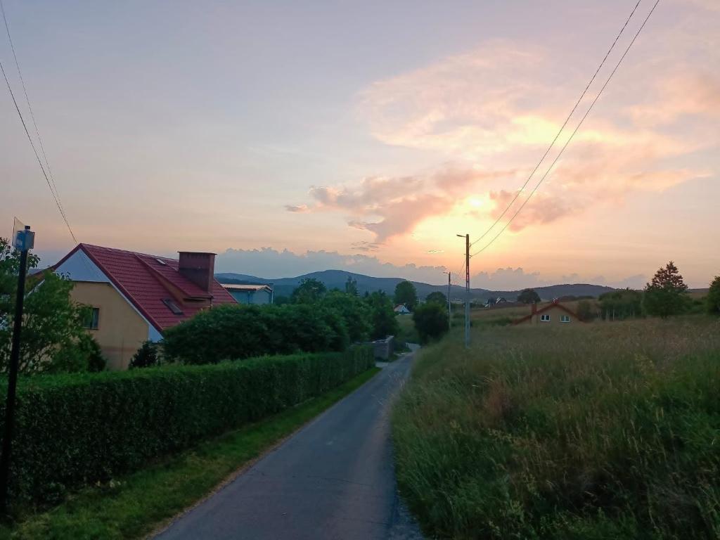 a road leading to a house with the sunset in the background at U Zbyszka in Kamienna Góra