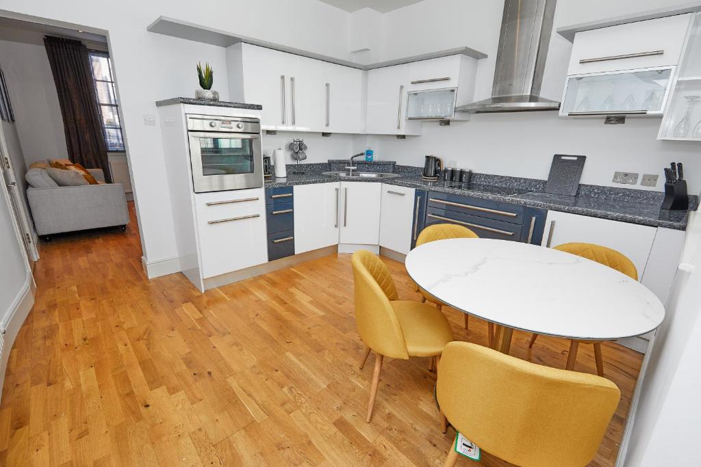 a kitchen with a table and chairs in a kitchen at Derby Cathedral Town House - 2 mins walk to city - FREE secure parking in Derby