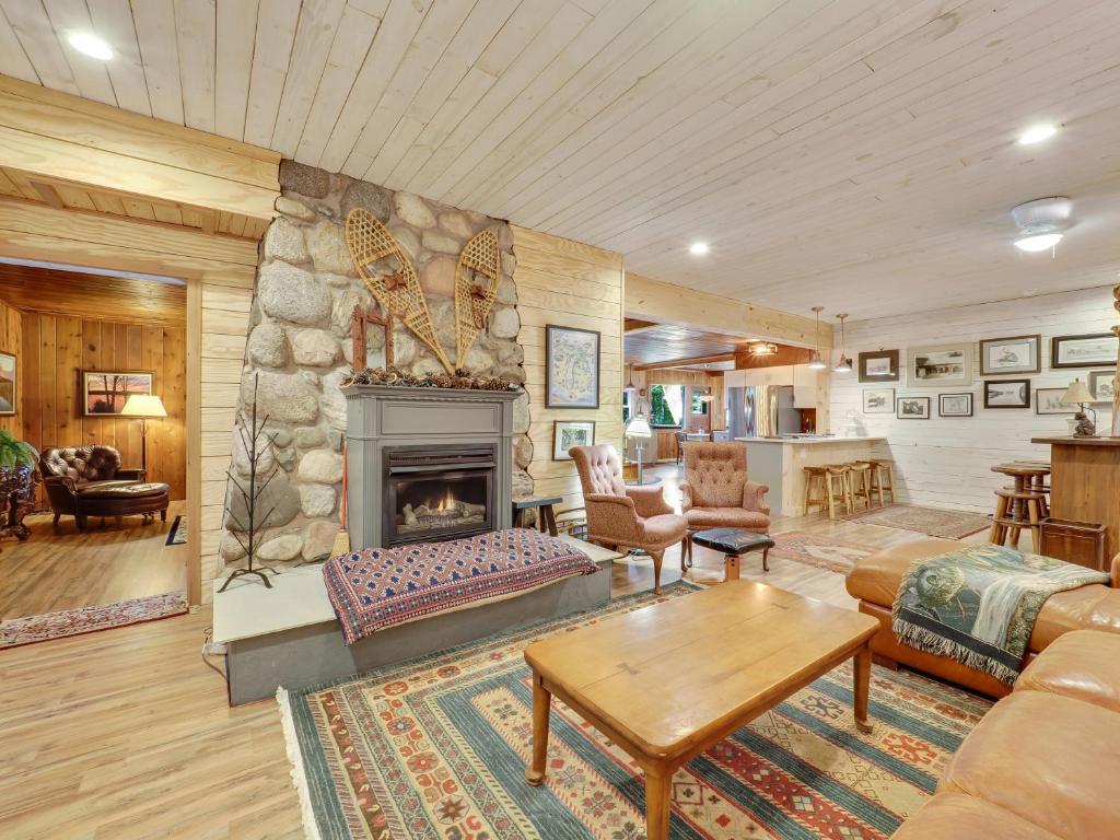Una sala de estar con chimenea y una mesa. en South Arm Shores, en East Jordan