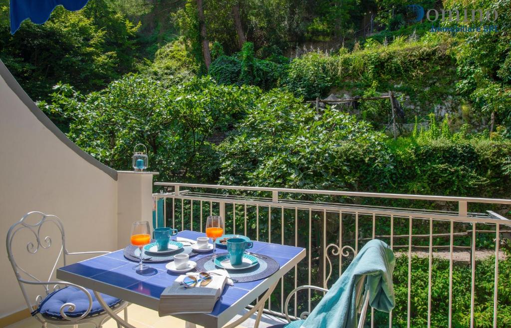 une table bleue avec deux verres sur un balcon dans l'établissement Casa Fornillo, à Positano
