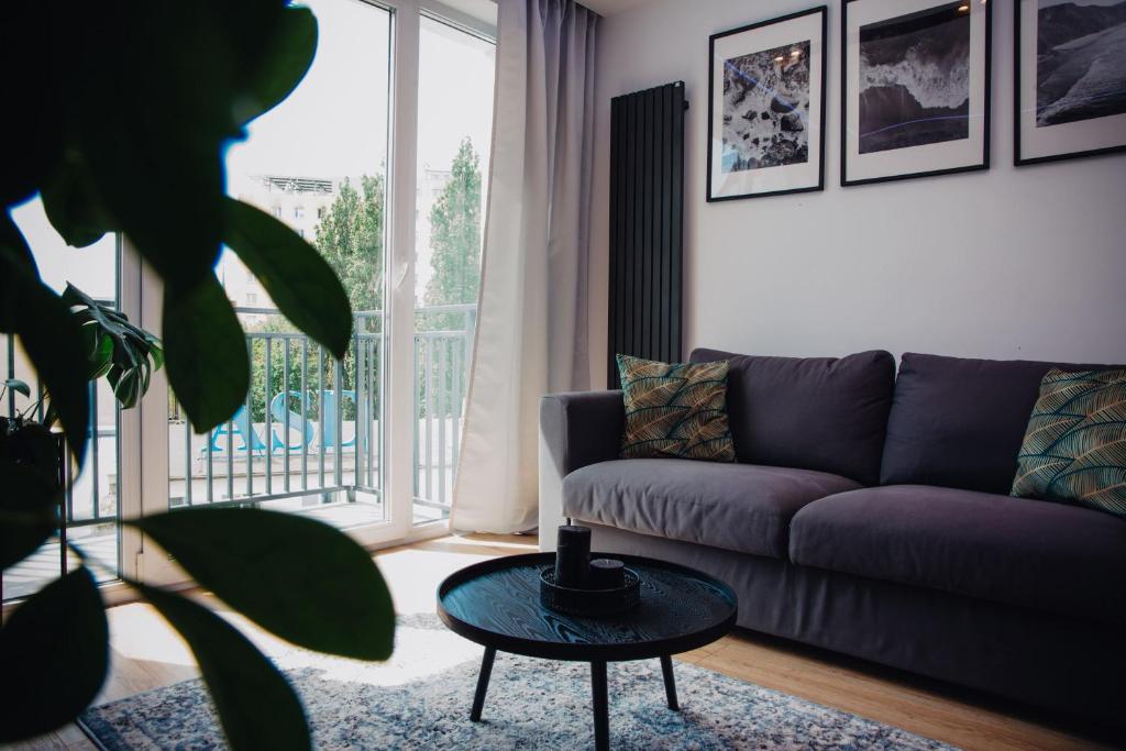 een woonkamer met een paarse bank en een tafel bij JBHotels Apartament Prestige in Szczecin