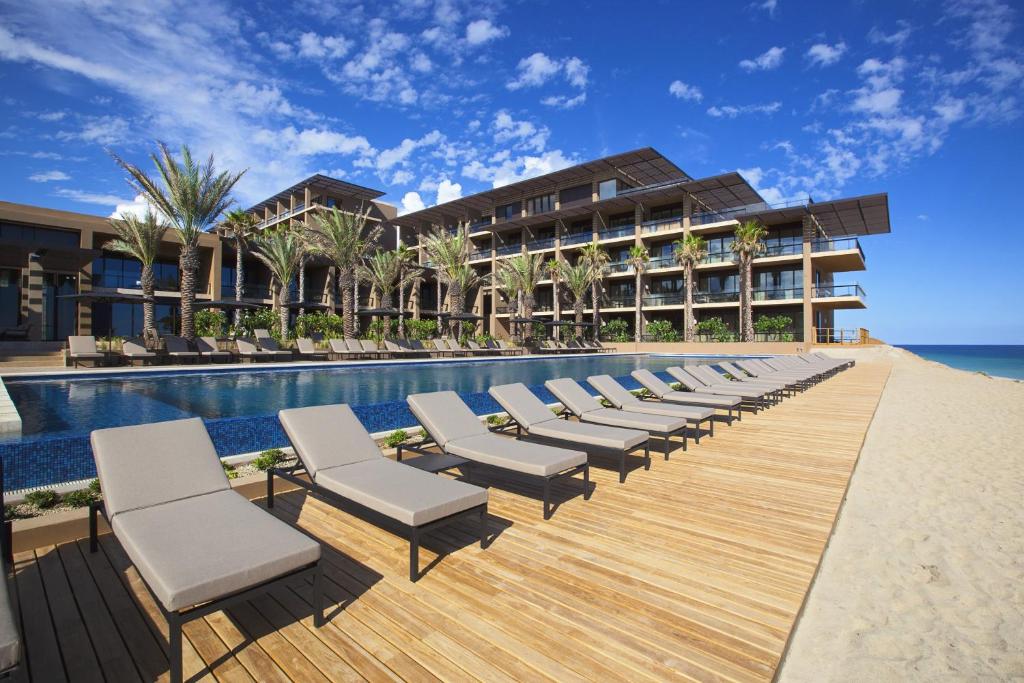 una fila di sedie a sdraio accanto alla piscina del resort di Casa Maat at JW Marriott Los Cabos Beach Resort & Spa a San José del Cabo