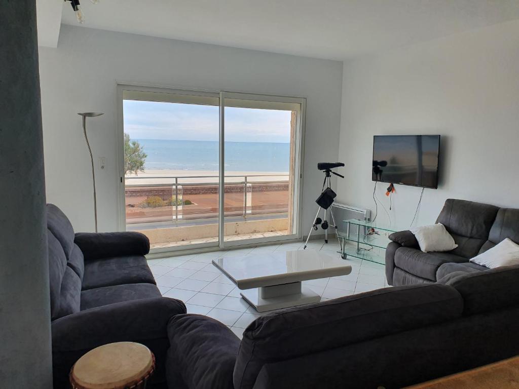 a living room with two couches and a view of the ocean at T4 Front de mer Valras Plage in Valras-Plage