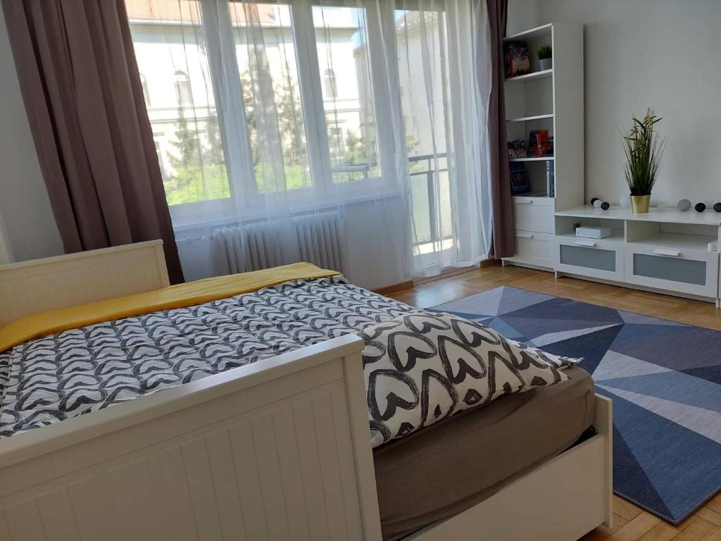 a bedroom with a bed in a room with windows at B30 Apartman in Budapest