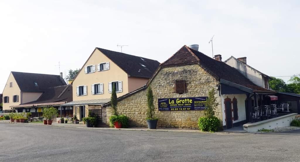 um edifício ao lado de uma rua em Hotel La Grotte em Sagy