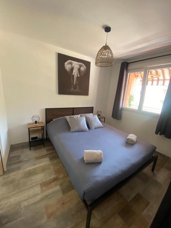 a bedroom with a bed and a window with an elephant picture at appartement vue mer avec place de parking privée in Sainte-Maxime