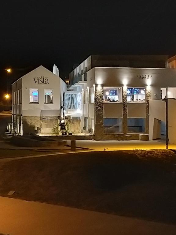 a white building with a sign on it at night at 5ª Vigia in Porto de Mós