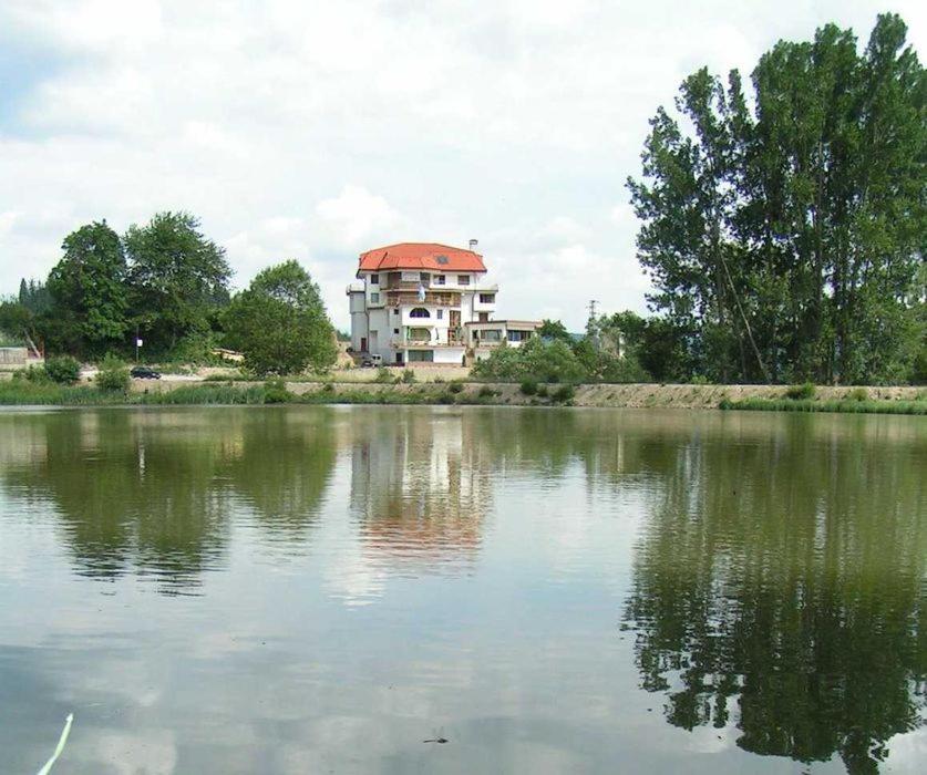 una casa sentada a un lado de un lago en Семеен хотел Кристал, en Smolyan