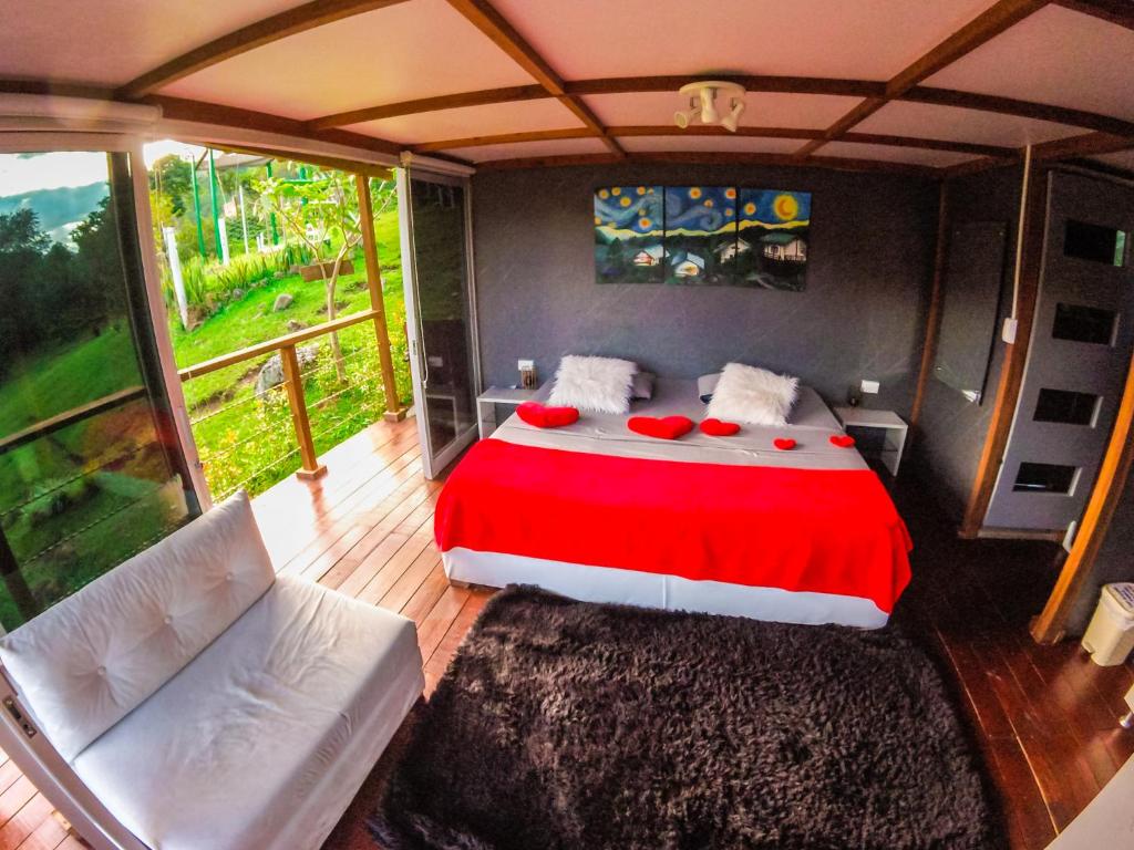 um quarto com uma cama com um cobertor vermelho em Glamping Adrenalina Extrema em San Agustín