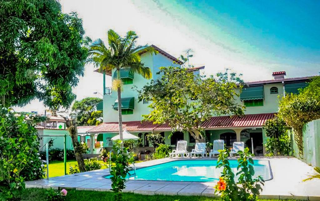 uma casa com uma piscina em frente em VOA Pousada Dos Jasmins em Serra