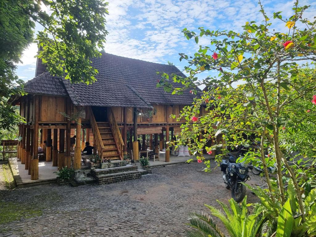 a building with a motorcycle parked in front of it at Muong Bi Homestay - Uncle Lon - Luy Ai village in Hòa Bình