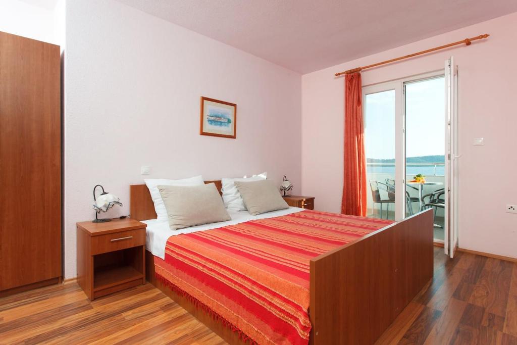 a bedroom with a bed with a view of the ocean at Apartments Alajbeg in Trogir