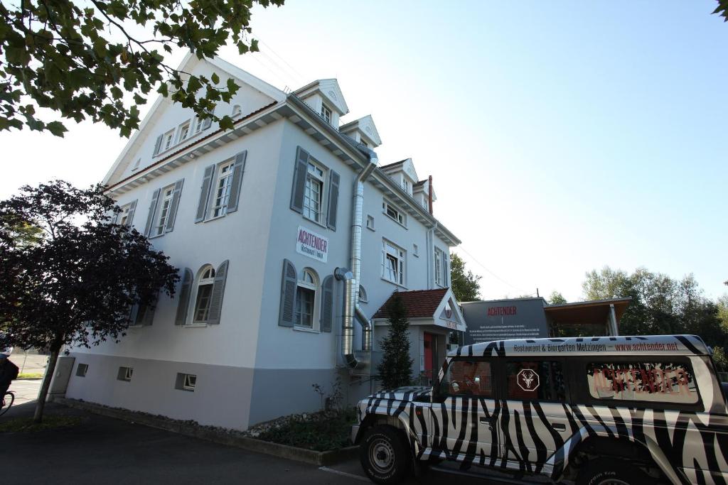 eine Limousine, die vor einem weißen Gebäude parkt in der Unterkunft Achtender in Metzingen