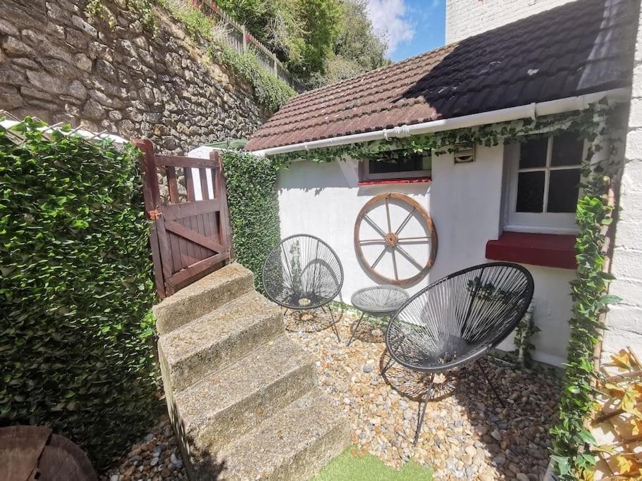 a house with two chairs and a fence and stairs at Shore Thing - Just a stones throw from the beach in Sandgate