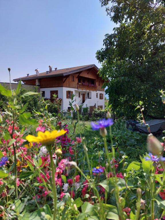 un giardino fiorito di fronte a una casa di Oberschoeberlehof a Merano