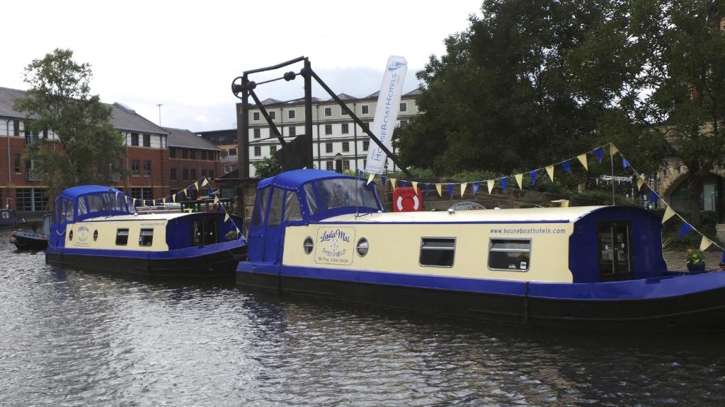 dois barcos azuis e brancos num rio em Houseboat Hotels em Sheffield