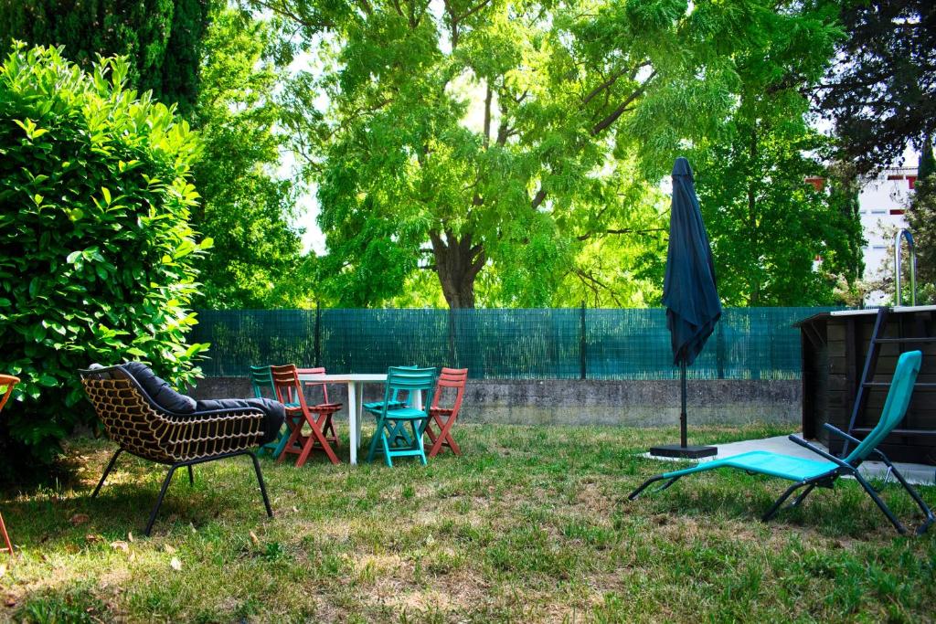 卡爾卡松的住宿－Agréable maison 3 chambres avec piscine，一个带椅子和桌子的庭院和一把雨伞
