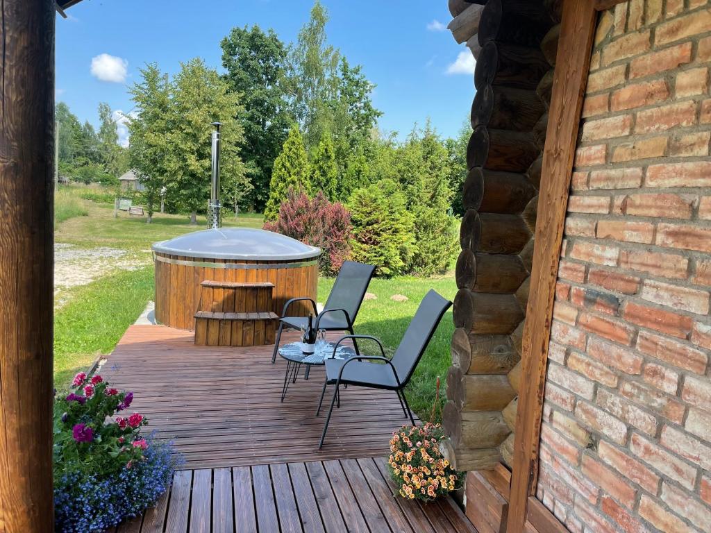 een terras met een hot tub en een tafel en stoelen bij Brīvdienu māja “Dzirnavnieki” in Bauska