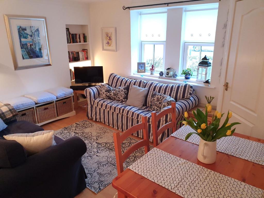 a living room with a couch and a table at Stoney Creek Cottage in Crail