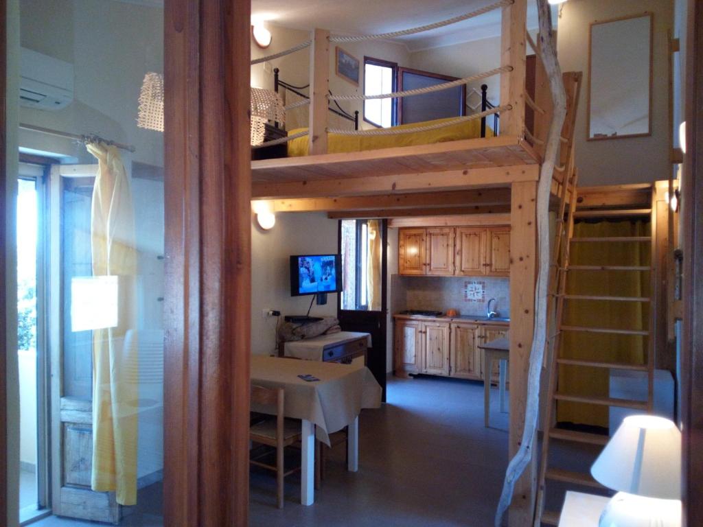 um quarto com uma cama alta e uma sala de jantar em La spiaggetta Maladroxia BIANCA em Maladroxia