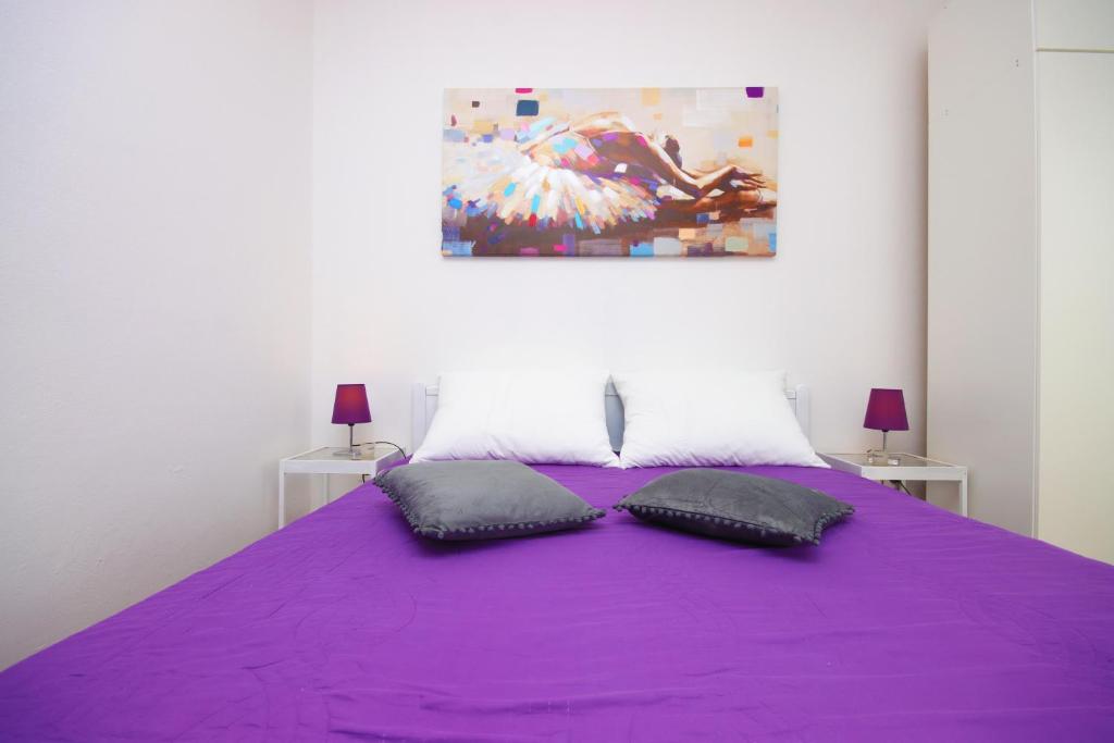 a purple bed with two pillows on top of it at Apartments Nina in Cavtat