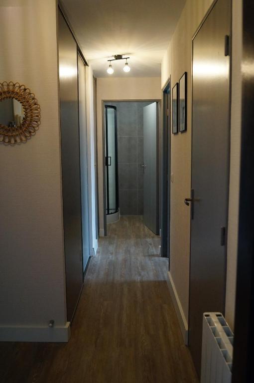 - un couloir long avec des portes et du parquet dans l&#39;établissement Elgebar YourHostHelper, à Caen