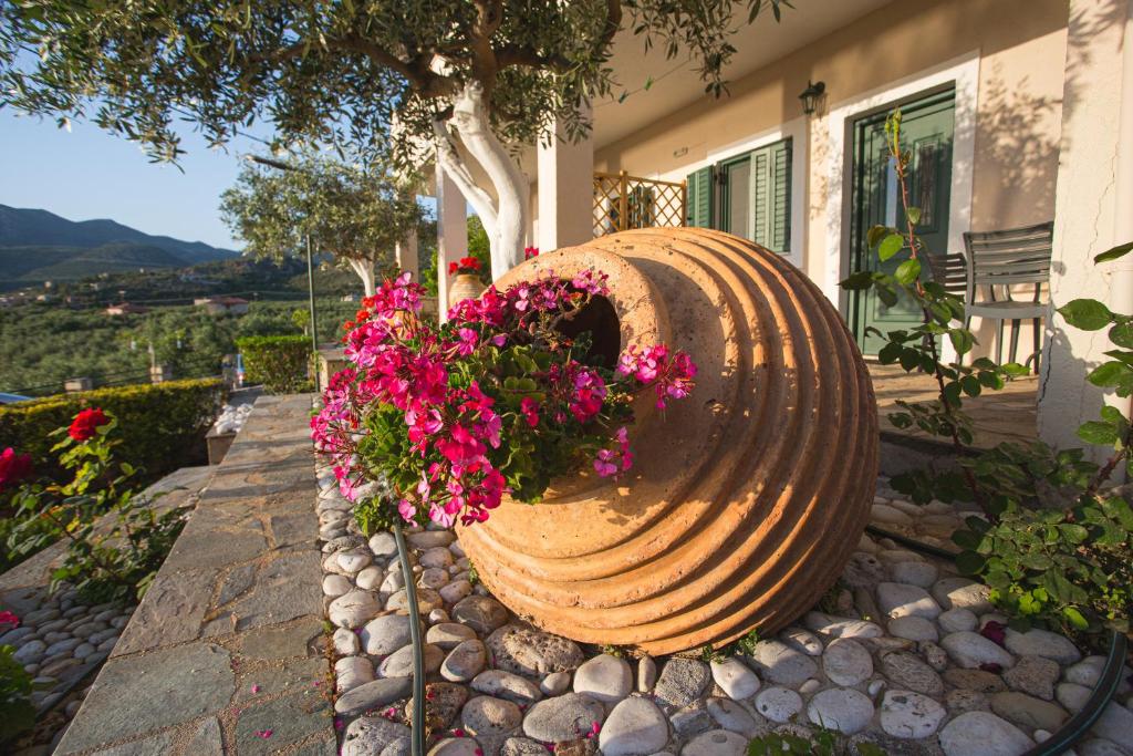 a large vase with flowers in front of a house at Palataki in Kardamyli