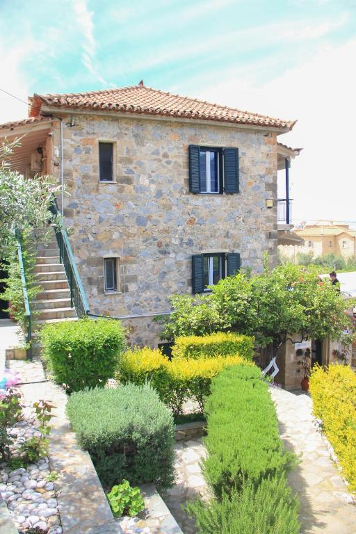 a stone house with a garden in front of it at Palataki in Kardamyli
