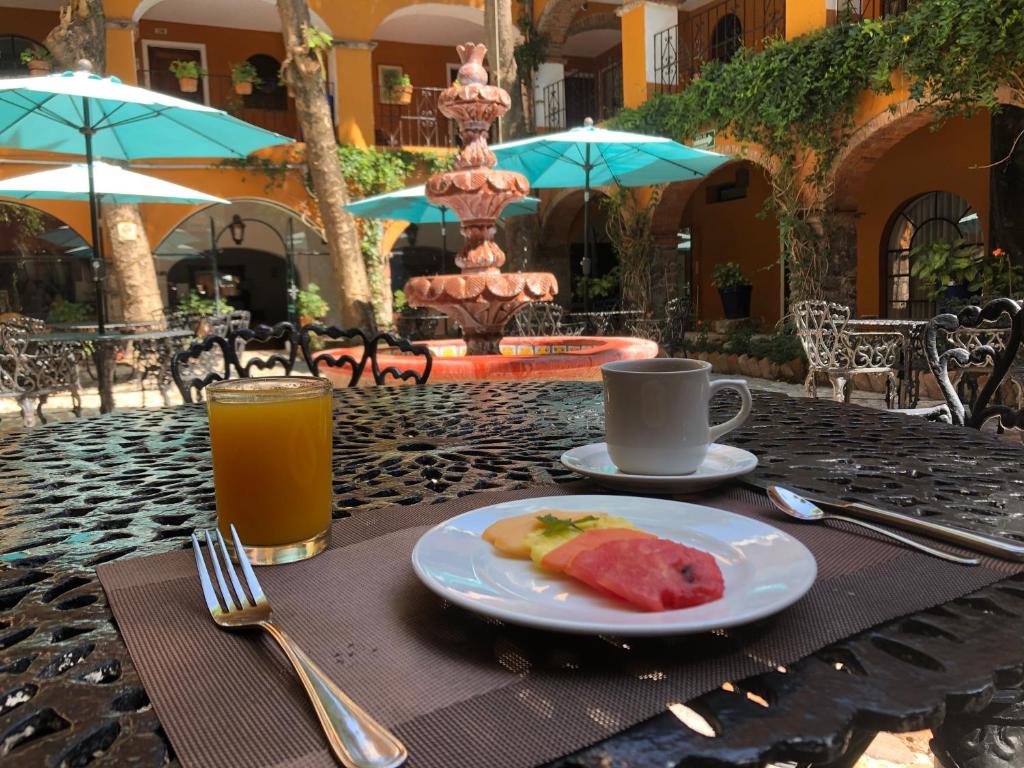 a table with a plate of food and a drink at Hotel Hacienda Monteverde San Miguel de Allende in San Miguel de Allende