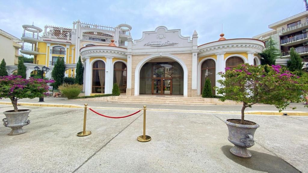 a building with two potted trees in front of it at Bratanov Harmony Monte Carlo in Sunny Beach
