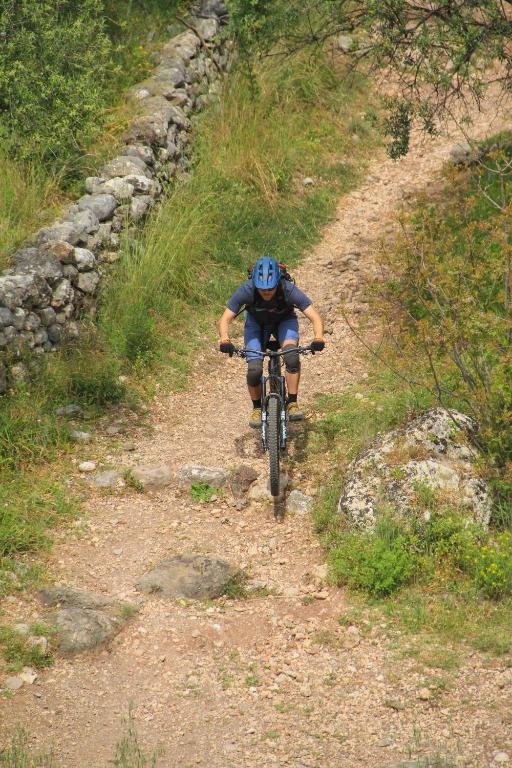 a man riding a bike down a dirt road at Palataki in Kardamyli