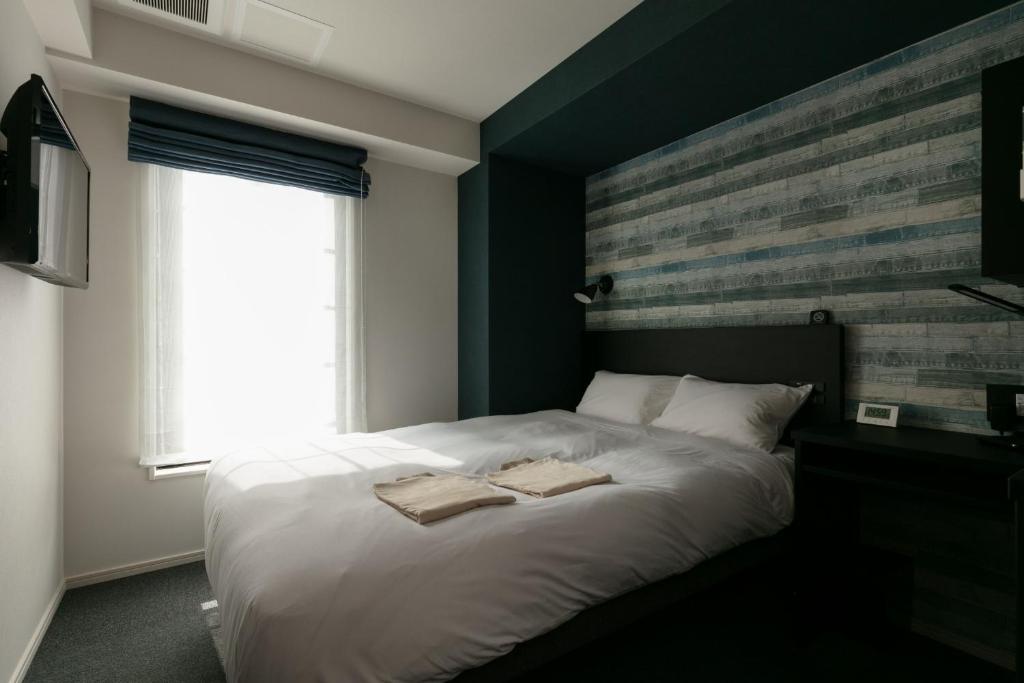 a bedroom with a bed with two towels on it at HOTEL TABARD TOKYO - Vacation STAY 62622v in Tokyo